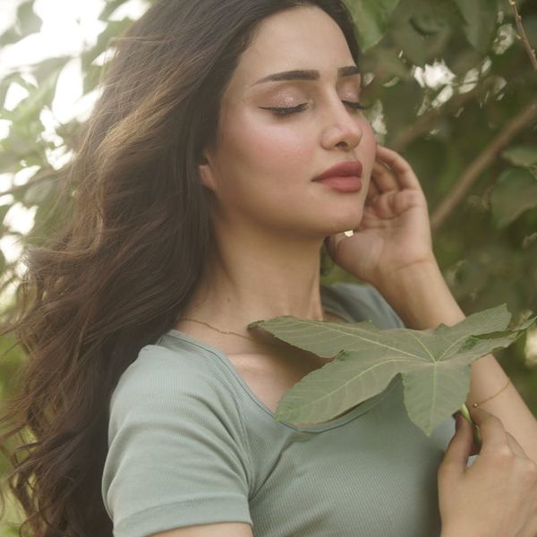 Woman with calm and focused expression, surrounded by abstract light elements.